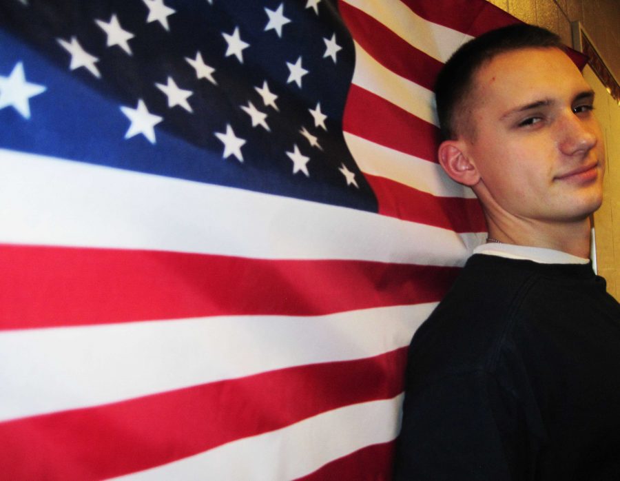 Junior Alex Carmeli poses by the flag that represents the country he is set on serving in the future. “I joined because it seemed like fun,” said Carmeli. “Plus we also learn practical things such as combat engineering, infantry and first aid.”