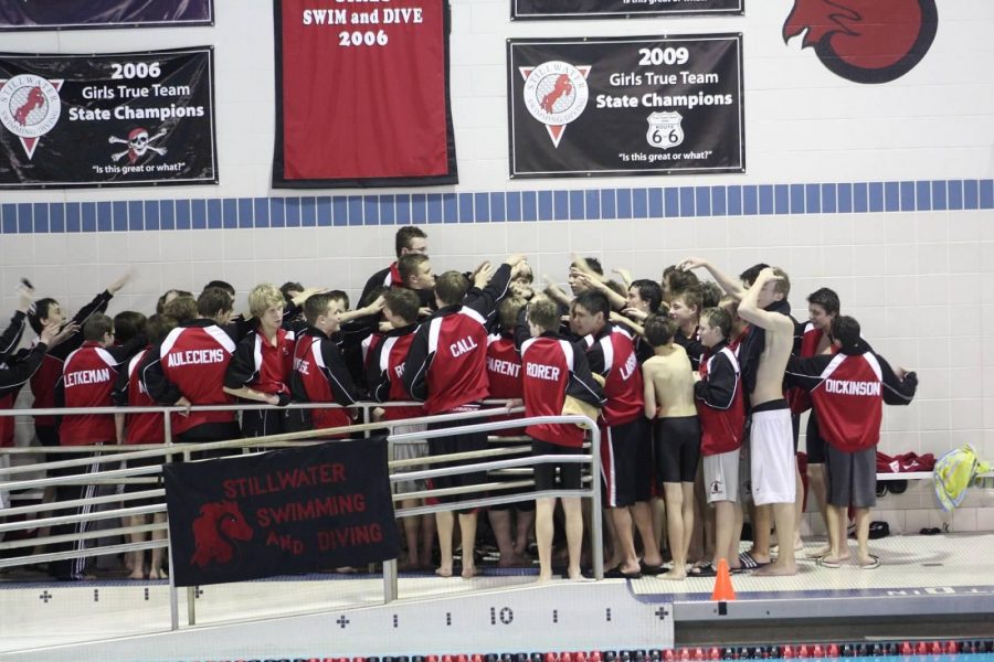 The boys’ swim team is in a huddle after a successful meet.
