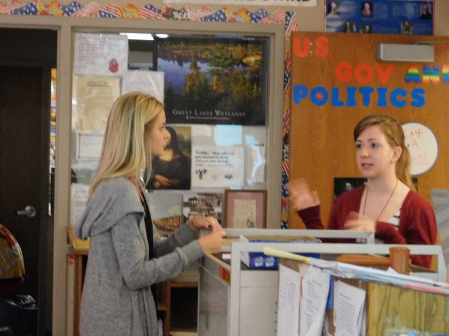 Senior Erica Oren, one of the presidents of Amnesty club, speaking to junior Corri Gardner during the meeting on Oct. 2. Oren’s goal is to work with administration to sell a healthier version of popcorn “...because that’s a better option than just cutting out all together.” 