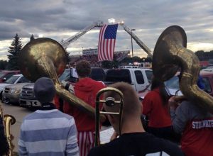 The American Flag in the background hangs in remembrance of those lost on 9/11. The pep band dedicated their performance to those lost 12 years ago.
 Photo By Lily Marchan