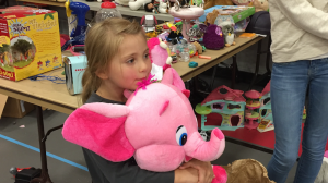 A young girl clutches her new favorite stuffed animal. I think a lot of people came away with really good deals, orchestra teacher Zach Sawyer said.
 Jonathan Rustad