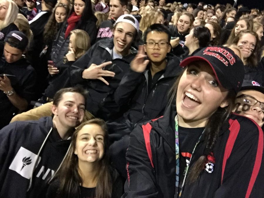 A group of students pose for a photo taken via selfie stick at a Ponies home football game. At football games if you pull out a selfie stick, people gather around and it gives them an excuse to talk to you! said Senior Brooke Espelien. 