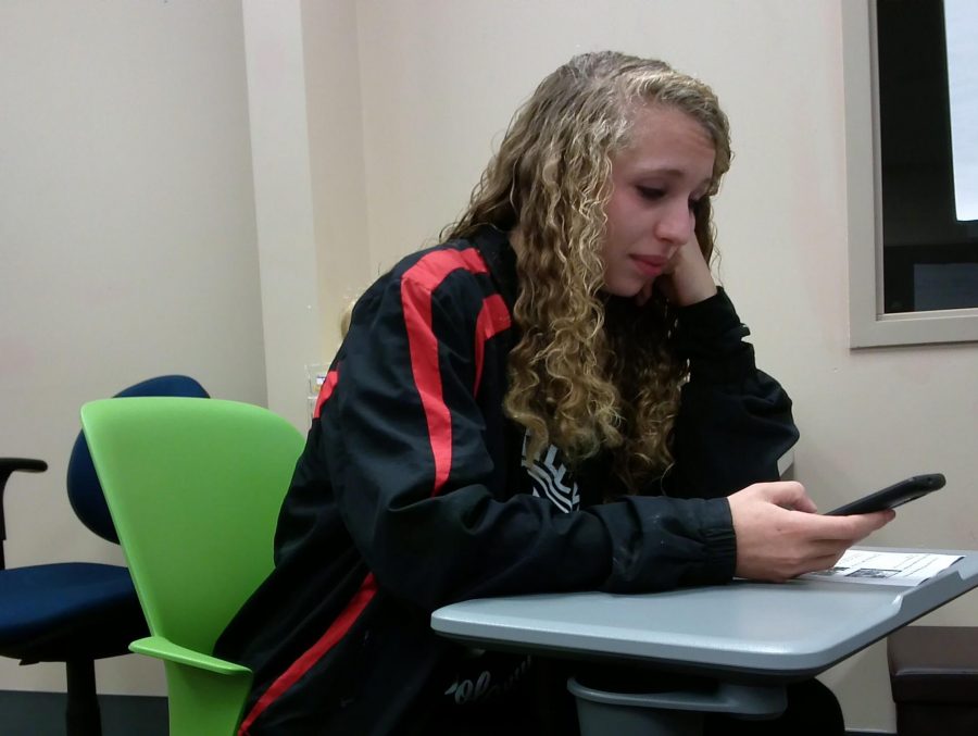In Newspaper, junior Rose Stobener is on her phone while Joslyn Reiche learns how to take a good picture. Rose says, QUOTE