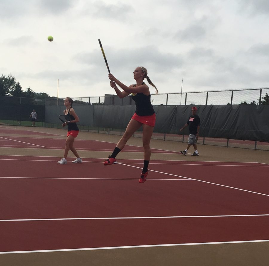 Junior Emma Germundson in action during warm ups with senior partner Olivia Anderson. Germundson said, If you know your partners strengths and weaknesses, you are more likely to work better as a team.  