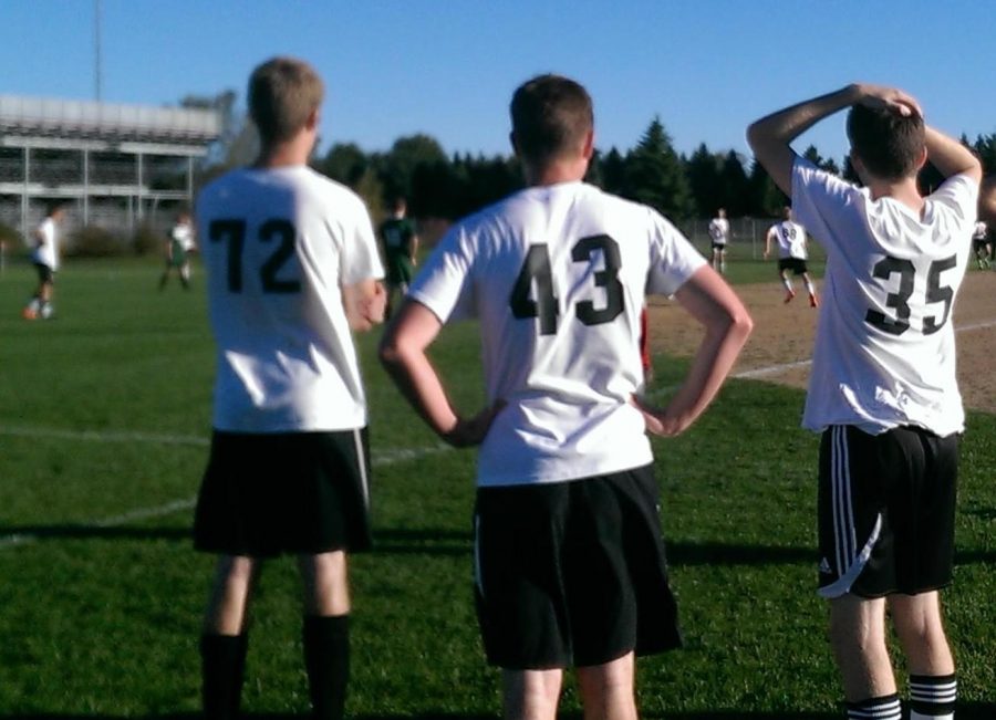 Jack Nelson, number 43, watches his JV Soccer team from the sidelines with his teammates Jonas Larson and Sam Luloff.
