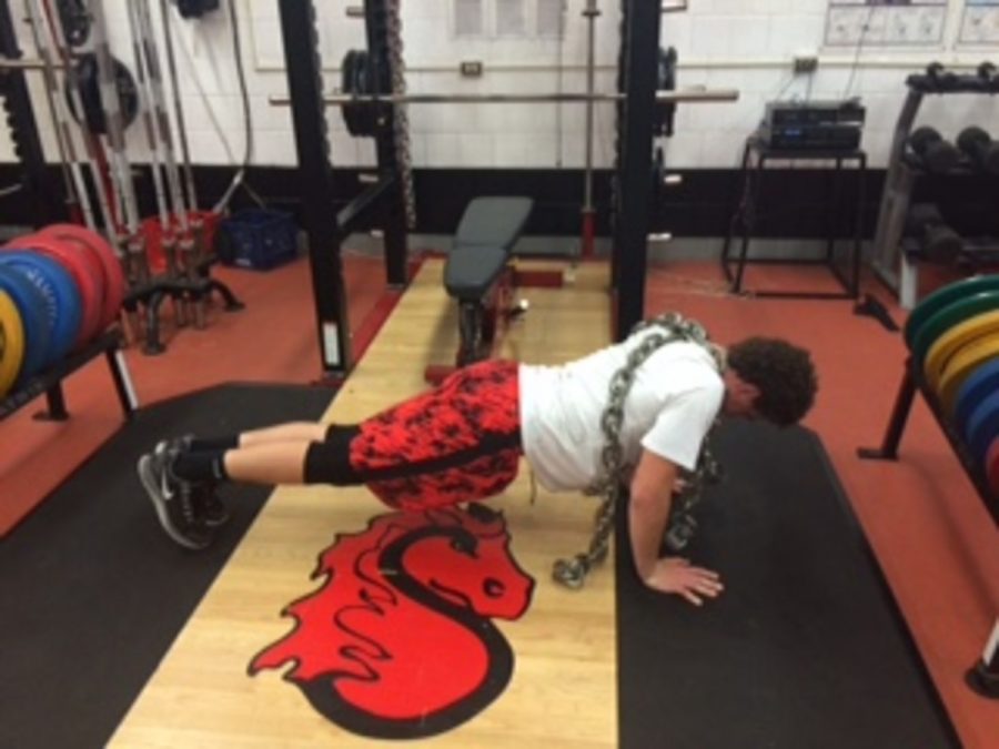Junior Aidan Steeves going to the max by not only doing push ups with his own weight but with heavy chains on his back. Preparing him to put the team on his back in times of need for the upcoming football season. “The goal is to build strength in the off-season for any athlete through the use of free weights, speed drills, and core endurance, coach Mike Weiss said.                                                 