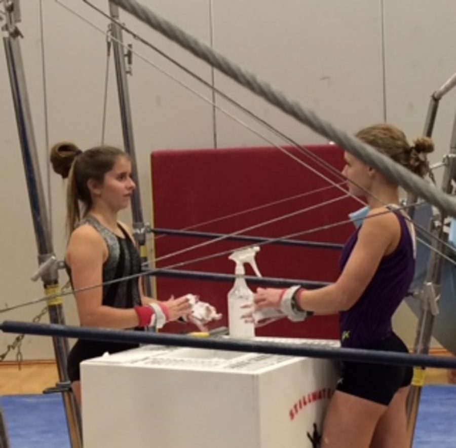 Team+members+Linnea+Rusted+and+Danielle+Keran+put+chalk+on+their+hands+as+they+prepare+to+practice+the+uneven+bars.+Chalk+helps+the+gymnasts+to+grip+onto+the+bars+so+injuries+like+slipping+do+not+happen.+Chalk+also+absorbs+sweat+and+it+protects+the+gymnasts+hands.%0A%E2%80%9DMy+favorite+skill+on+the+uneven+bars+is+giants.+They%E2%80%99re+a+skill+where+you+basically+start+in+a+handstand+swing+around+the+bar+and+finish+back+in+a+handstand.+You+typically+do+two+giants+in+a+routine+then+let+go+to+dismount.+They+were+pretty+scary+to+learn+but+once+I+got+the+hang+of+them%2C+they+were+actually+really+fun+to+do%2C%E2%80%9D+junior+Rustad+said.