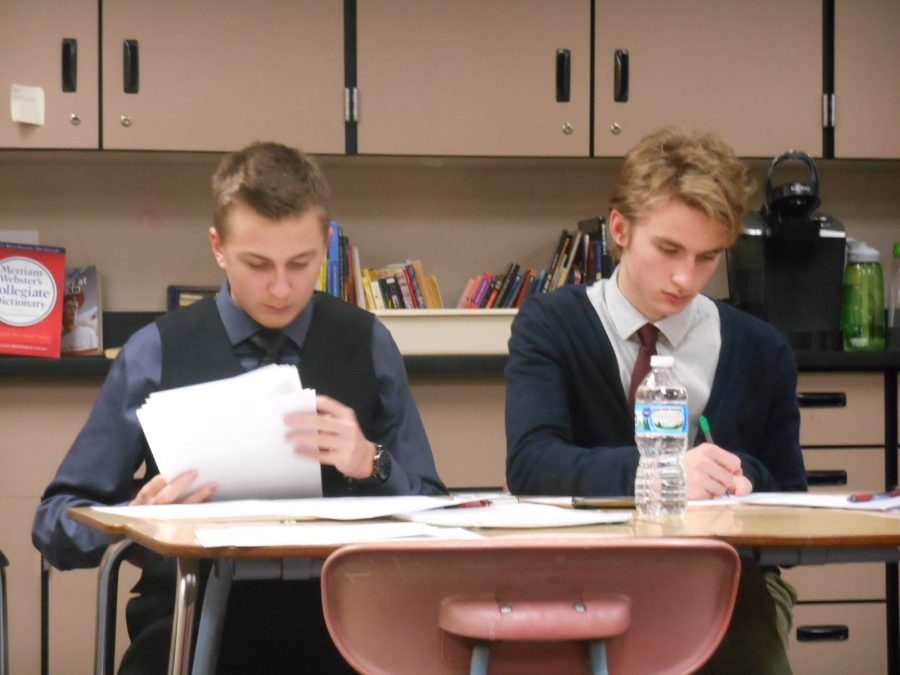  “It’s a heck-of-a-lot more fun in the spotlight. Before, it’s all about thinking and working out what you want to say and how you will go into the debate, and when you are in the spotlight, you’re just kind of in the moment with it and that’s just a lot more fun,” senior Jack Franz says. Working as a team, Franz (right) and senior Justin Hannasch (left) get organized and take notes to assist them later in the debate. 