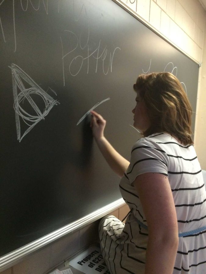 The Engllish flex room needs to be properly decorated for the Hippogriffs meeting. Junior Elizabeth Morrissey draws deathly hallows symbols on the chalkboard before they begin. While the club is based off of the Harry Potter series, its more based on the theme of doing good in the world. Anyone can join.