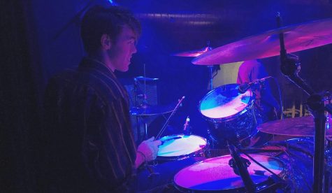 Sophomore Evan Cambell, looking out into the crowd gathered at the small bar in Mahtomedi. Cambell plays the drums for the band him and his two other brothers created.