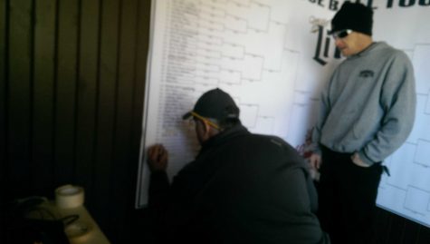 Gerry Brine, co owner of Brines Bar and Restruant begins the day of bocce ball tournaments by filling out the starting sore board. This outlines who will play who in this double elimination game. He says, Its kind of annoying but they come up with some pretty funny names.