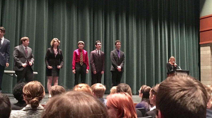 Noah Schraut, Daniel Meyer and Ace Oubaha (left to right) are on the stage awaiting their awards.  Our team received runner up in the first tournament which is fantastic, junior Greta McClellan says.
