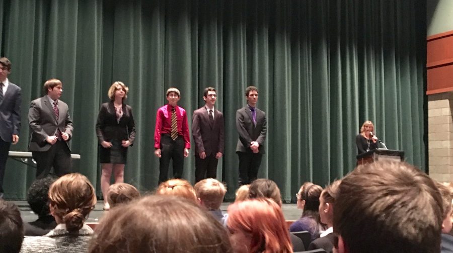 Noah Schraut, Daniel Meyer and Ace Oubaha (left to right) are on the stage awaiting their awards.  "Our team received runner up in the first tournament which is fantastic," junior Greta McClellan says.