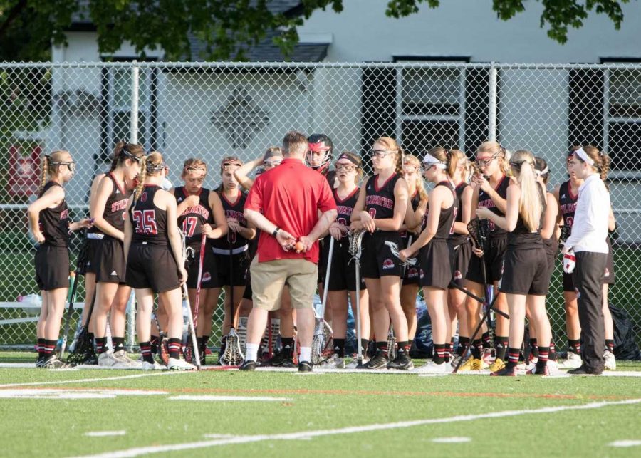 The Stillwater Girls Lacrosse team huddles around their coach Rick Reidt during one their games last spring. Carly deserves to play lacrosse at a college level. She had refined her skills and put in the hours she needed to, junior Lucia Bischoff says.