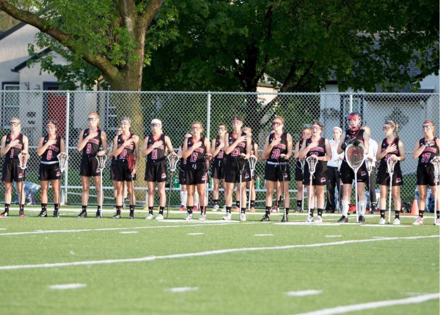 The Stillwater Girls Lacrosse team stand for the national anthem before one of their games last spring. She works hard every day at practice and in the off season she is always putting in extra time to better herself, senior Sam Houle says.