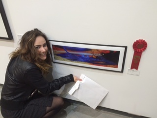 Senior Anna Craggs has to crouch to be beside her piece. She could hardly spare a minute for a photo as visitors began lining up to ask her about her piece. “I am really proud of what everyone has done here. The hard work of all the other artists just amazes me everytime. I am really thankful that I am able to be a part of this,” Craggs said.
