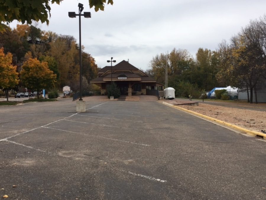 Wide shot of the front of the Zephyr Depot Building. This photo shows the environment of the building, and how old the parking lot is. It also shows us if the area of the building is lively, for example, the cars parked on the road.