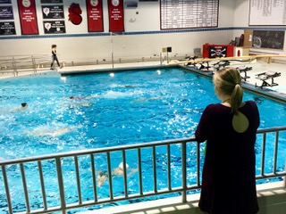 Photo By Bella Anderson - Sophie Ogaard is looking at the pool where her teammates are swimming, wishing she could be in there with them. Ogaard said, “I just miss swimming and being with my friends.”
