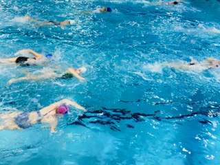 Photo By Bella Anderson - Teammates of Ogaards warming up for synchro practice. They are swimming freestyle to warm up for their big first practice of the club season. Ogaard said, “I get super irritated and almost like angry that I cant I cant do the thing that I love.”
