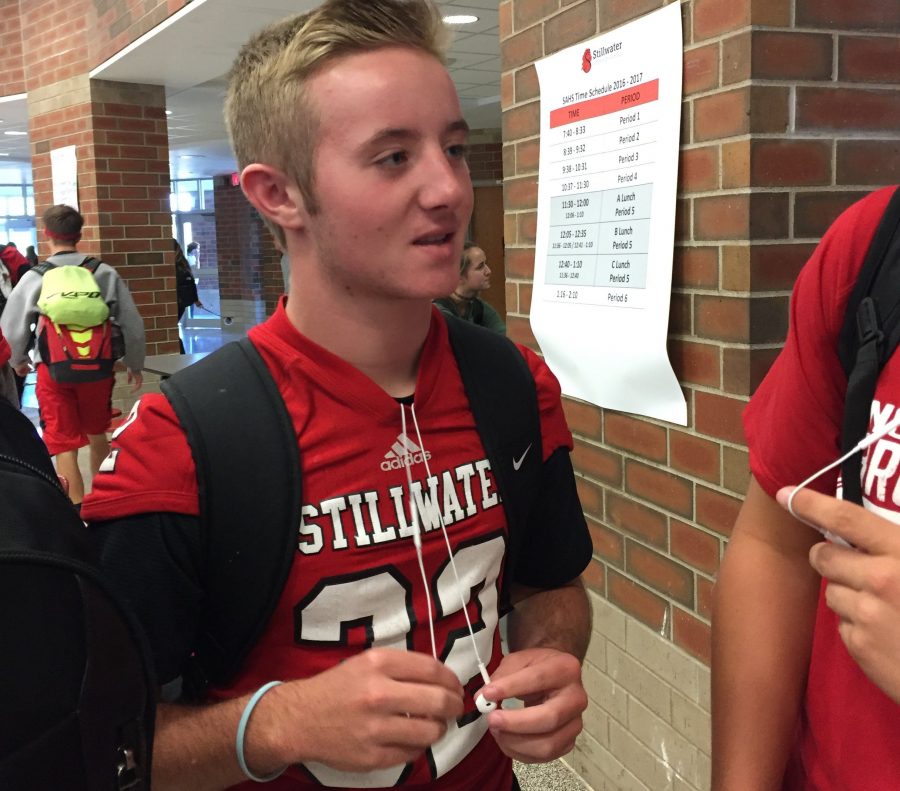 Photo by Hailey LaubscherA sophomore football player in the cafeteria talking to his friend. This is an example of players wearing their jerseys to dress up. Junior Brice Hafemeyer says, Its tradition to wear our jerseys on game days.