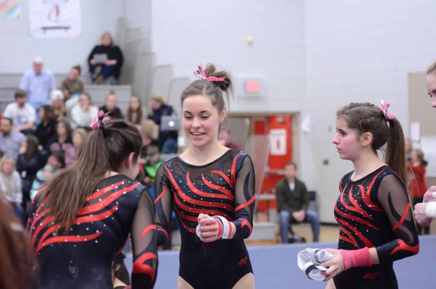 Juniors Maria Landherr and Danielle Keran during the meet, standing right in front of the mat. Landherr says, “It was right before a big run, I was getting a lot of encouragement to go do my best.”

