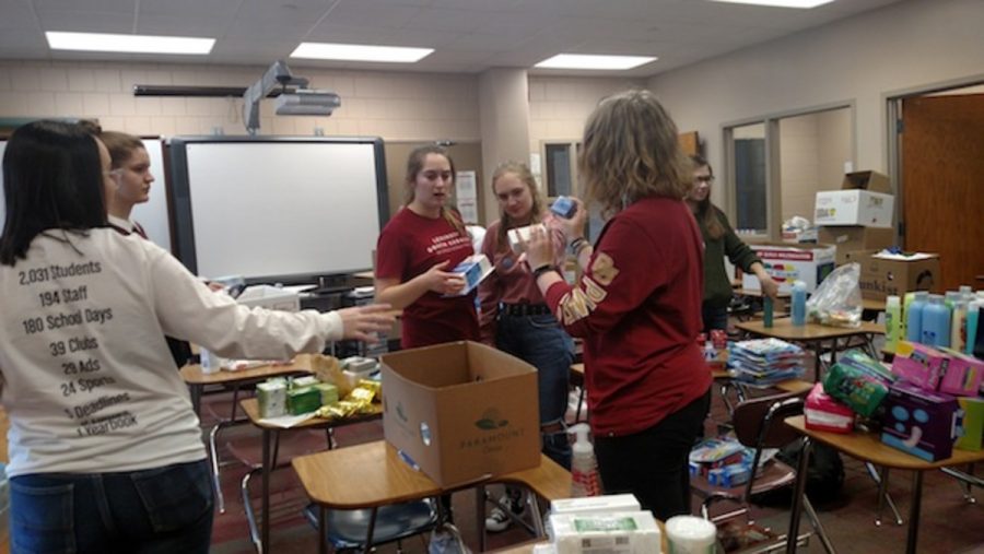 Members of Amnesty Club try to figure out what item is sorted into which pile. We had posters around the school and had different club members go around and talk to the classes. They actually provided the boxes to the classes, junior Amelia Torgerson says.