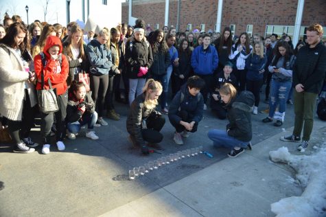 Seniors Maggie Jones, Chelsea Lai and Hannah Gilsdorf light 17 candles for the 17 Parkland victims during the March 14 walkout. It was kind of metaphorical. When the candle was lit, it represented their life, so it was emotional, Jones said.