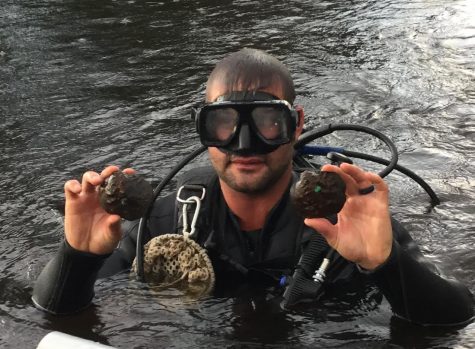 A man from the DNR attended a trip to the St. Croix with Chaplinksi and her students. He holds an endangered Winged Mapleleaf Mussel in each hand.