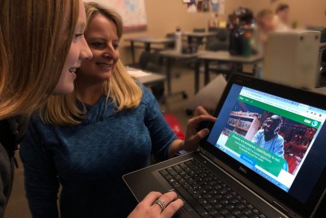 Spanish teacher Kirsten Carter and senior Peyton Classon browse Kiva for loan recipients. Its a great way to make an impact on someone elses life, and super fun, co president Isabel Bartosh said.