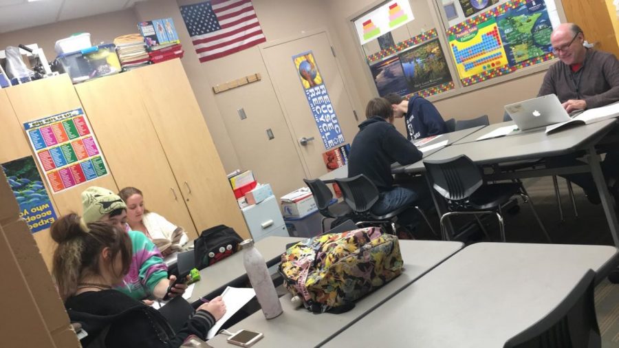 ALC students work hard on their homework while their teacher Tom Wendt talks with his students. Wendt is very close with his students.