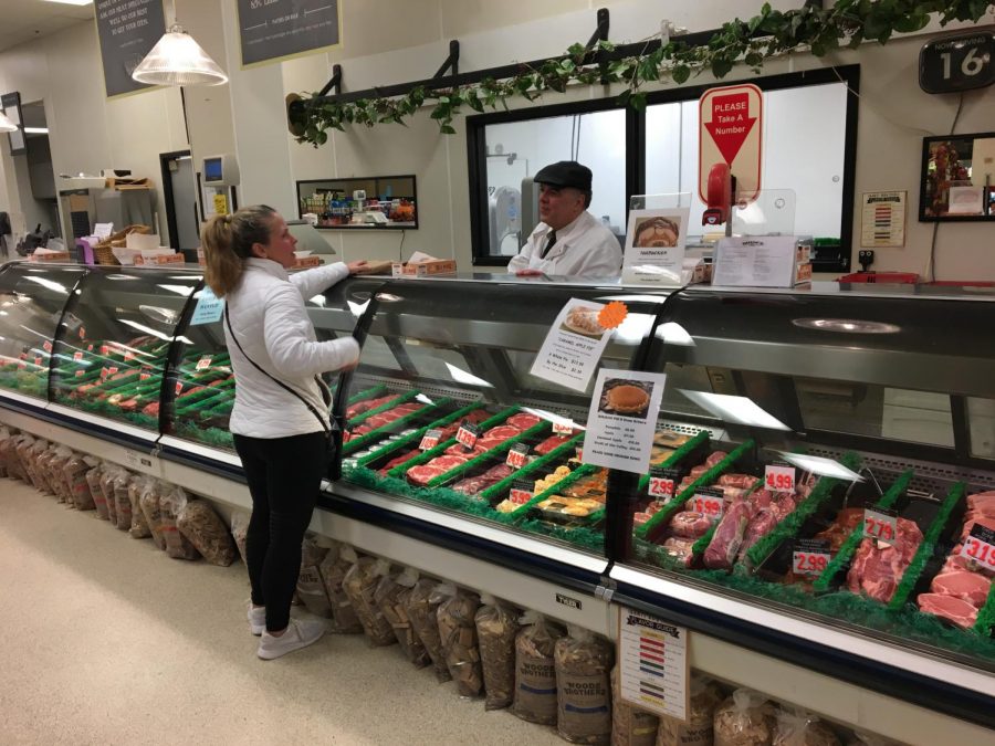 Matt Brine chats with a customer while helping them decide on dinner. Matt works with his brother Mark in the meat department as co-owners, along with sister Polly Hoy, who works in the kitchen as well as clerical duties.