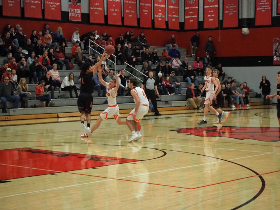 Senior Sam Hasan looks for an open player as he dribbles down the court. Stillwater faced off against against White Bear Lake and lost after a tough battle 83 to 60 on Jan. 8. 