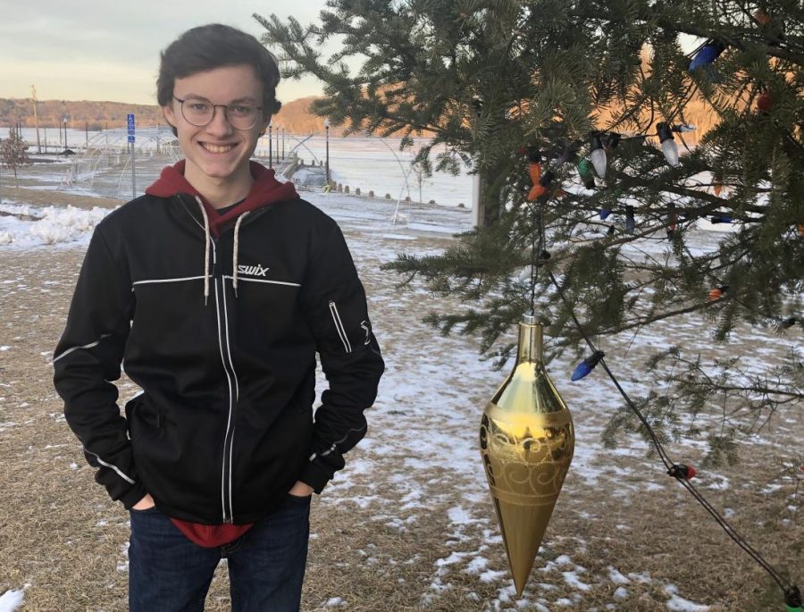 Junior Sam Ek waits by the holiday tree in Lowell Park next to the lights display for the lights to turn on at 4 p.m. The lights will remain in Stillwater through March. Theres something that is added to the lights since the lights are free and the ice castles you had to pay to go, Ek adds. 