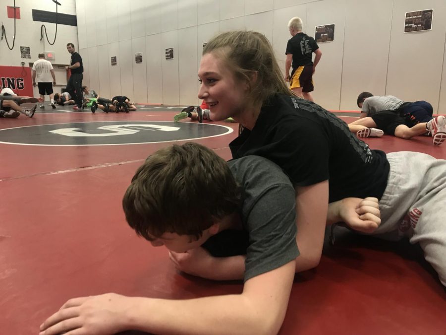 Junior Madi Horn tackles her wrestling teammate. Tackling is a common strategy in wrestling.