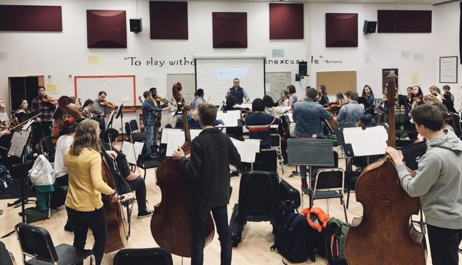 Concert orchestra works through a musical piece while be lead by director Zach Sawyer. The group leaves for Boston March 28. 