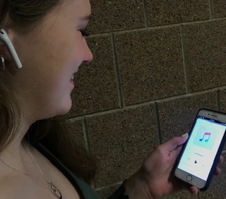 Junior Addy Oberg listens to music with her AirPods in between class while walking to her next class.