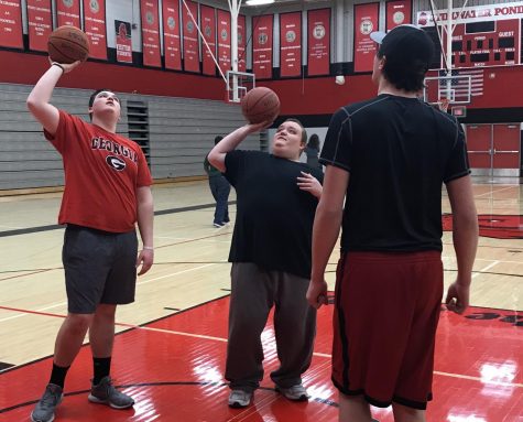 Physical Education teacher Paula Harrison turns the class over to seniors Noah Pasiuk and Thomas Haggard. They teach the class how to play basketball.