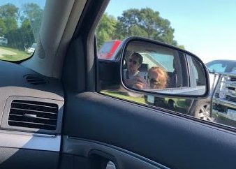 Sophomore Isaac Metraus uses his phone while stuck in traffic, not realizing the distraction he will be causing to the driver just inches away. With the new law that was proposed, there is a chance that Metraus could receive jail time for doing this.