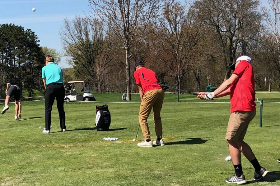 The boys golf team practices their swings for an upcoming tournament. The driving range allows them to improve their shot.