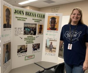 Kirsten Carter is showing off her BIZAA board. Listed on the poster are the kids that are being sponsored. Carter said she wants to continue this cub probably for the next 10 years at least.