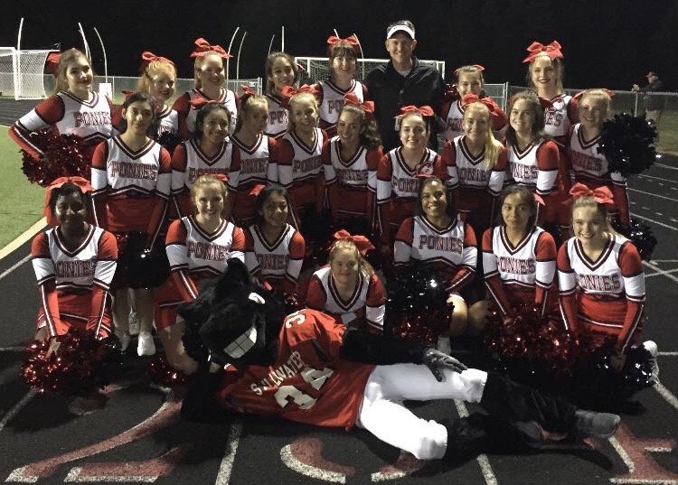 Pride, Principal Rob Bach and the cheer team gather for a quick picture during one of the home football games. Together they rally and cheer on the Ponies alongside the student section.  