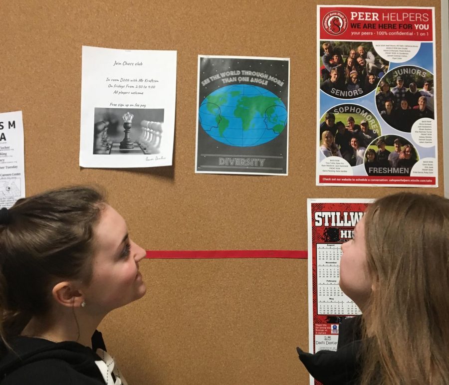 Juniors Ayuna Lamb-Hickson and Olivia Lind view the diversity poster for BLAST week. The BLAST week presentations are featured during the Black History Month presentation.