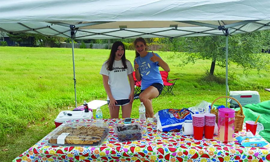 Juniors Emily Shanley and Johanna Teegarden smile during a Girl Scout fundraiser. Teegarden and Shanley have been in Girl Scouts together since first grade.
