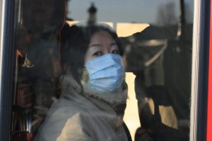 A tourist on a bus wears a mask to try to stop the spread of germs. 