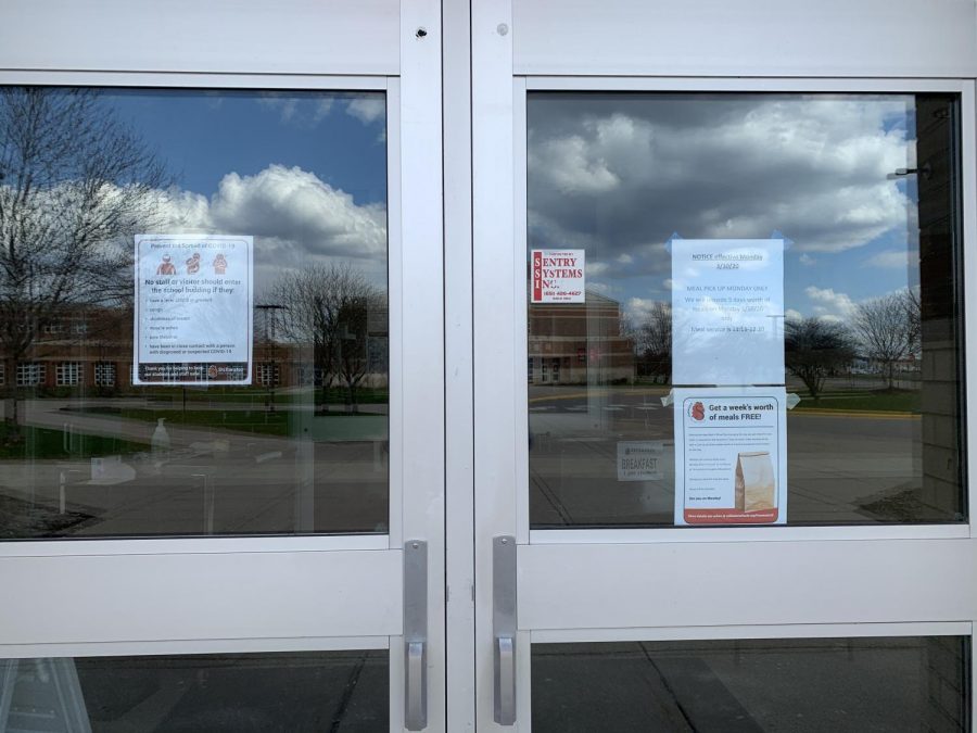 The doors to the cafeteria remain closed. One poster on the windows warn that no one with symptoms of coronavirus may enter the building, another explains the districts free meal pickup service.