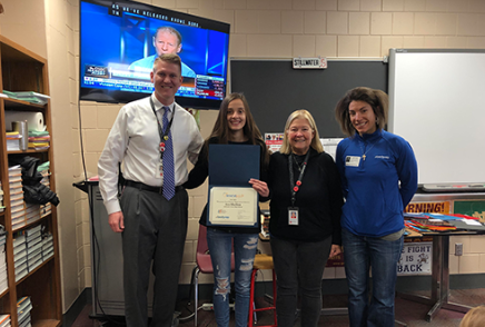Junior Ava Shelton stands with principal Rob Bach, marketing teacher Debbie Drummerhausen and Stephanie Musgrove as she accepts her award from the essay contest.