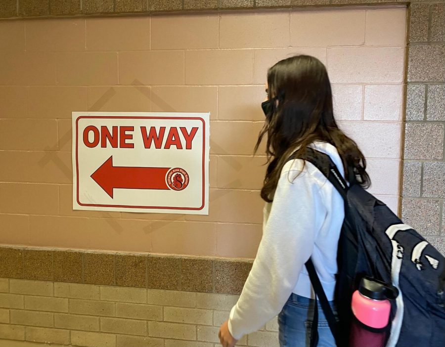 Junior Greta Sorenson abiding by the new preventions in the school. She is wearing a mask and following the one-way hallways, keeping herself and others safe from COVID-19.