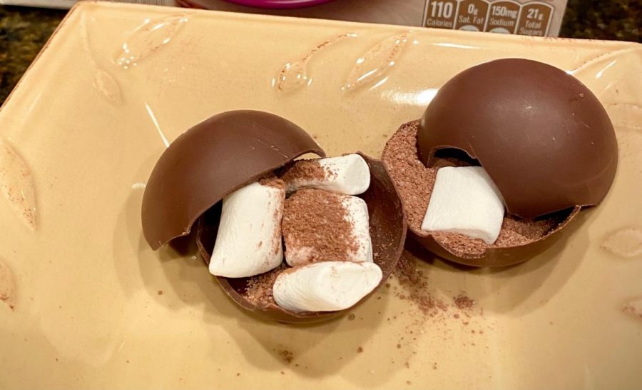 Hot cocoa bombs are cut in half to show what the inside holds. These treats will later be dropped into warm milk and dissolve into a hot cocoa drink. 