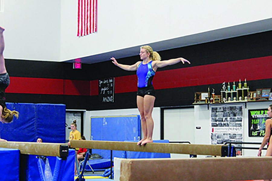 Senior Heather Wiehe practicing beams at the Stillwater high school gymnasium last Thursday. At the same time, the other gymnasts remain socially distanced. 