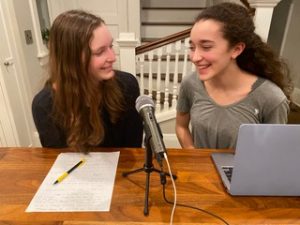 The Herbert sisters sit in their kitchen recording their newest episode. Hannah (left) has the script outline in front of her, and Paige (right) has the computer monitoring the audio and time theyve been recording. 